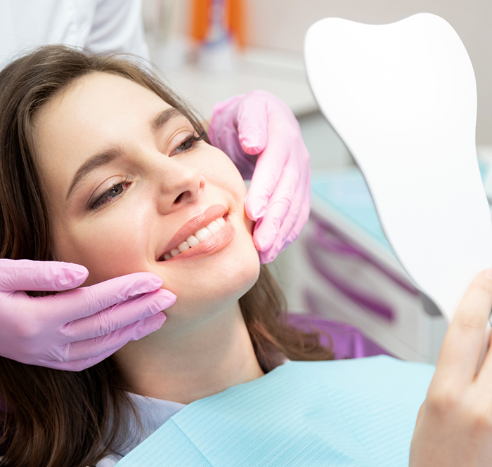 Female dental patient sitting back in chair and smiling