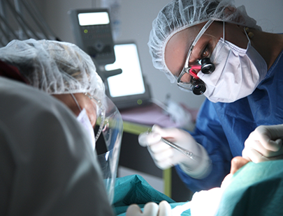 Dentists in masks placing a dental crown