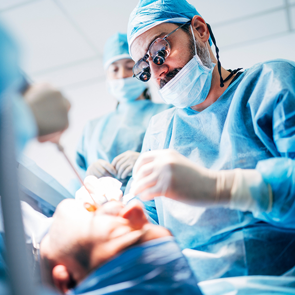 Dentist with mask treating a patient