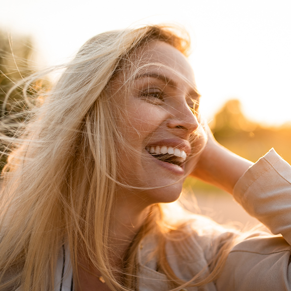 Blonde woman standing outside and laughing