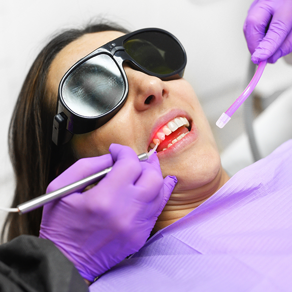 Dental patient in chair with dental laser and toothbrush