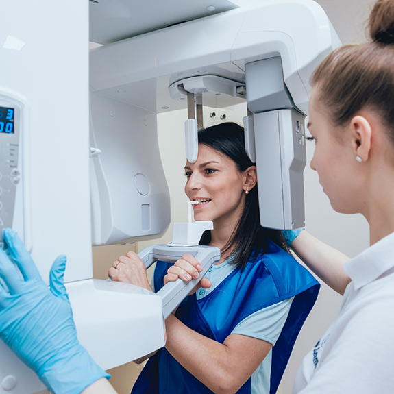 Dental team member using cone beam scanner on patient