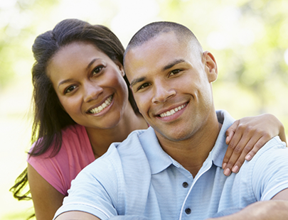 Woman hugging man from behind and smiling