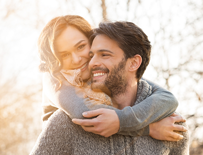 Man giving woman piggyback ride outside