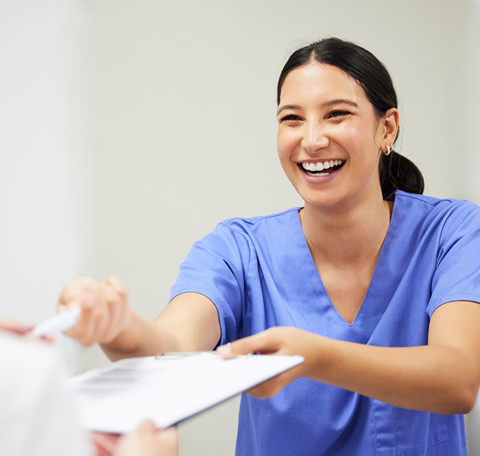 Dentist in blue shirt holding patient a pen