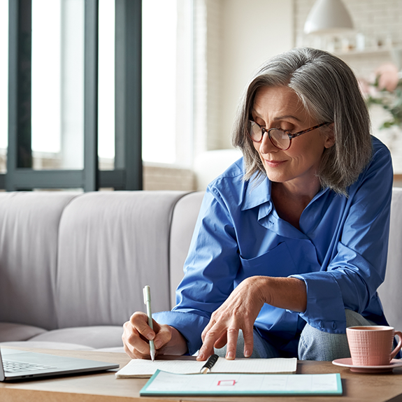 Woman in denim jack looking at papers on table