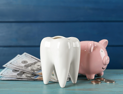 Tooth in front of money and piggy bank