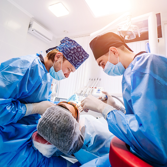 Dentists with masks treating a dental patient