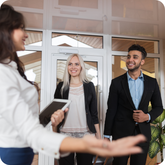 Man and woman greeted at front desk of dental office 