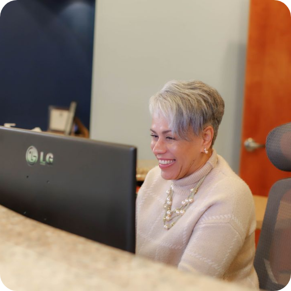 Woman at front desk typing on computer