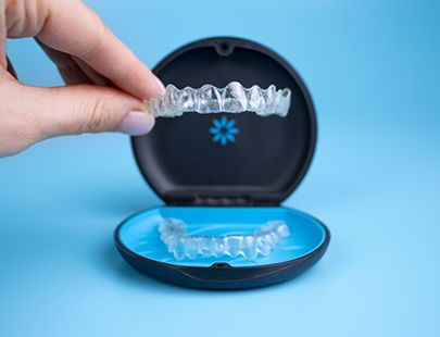 Hand taking clear aligners out of case