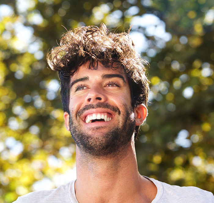 Man with beard standing outside and smiling