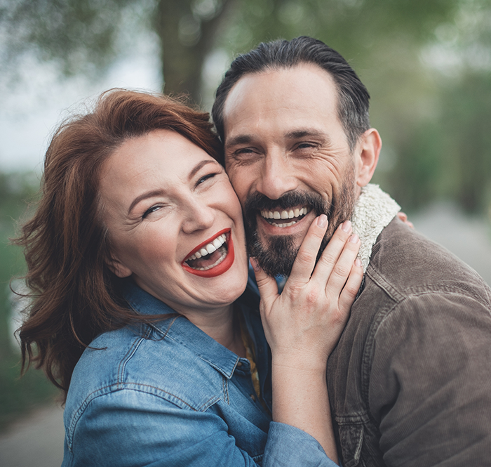 Man and woman standing outside and laughing