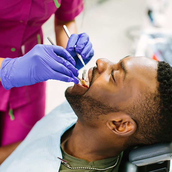 Man sitting dental chair having teeth examined