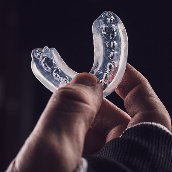 Hand holding an athletic mouthguard