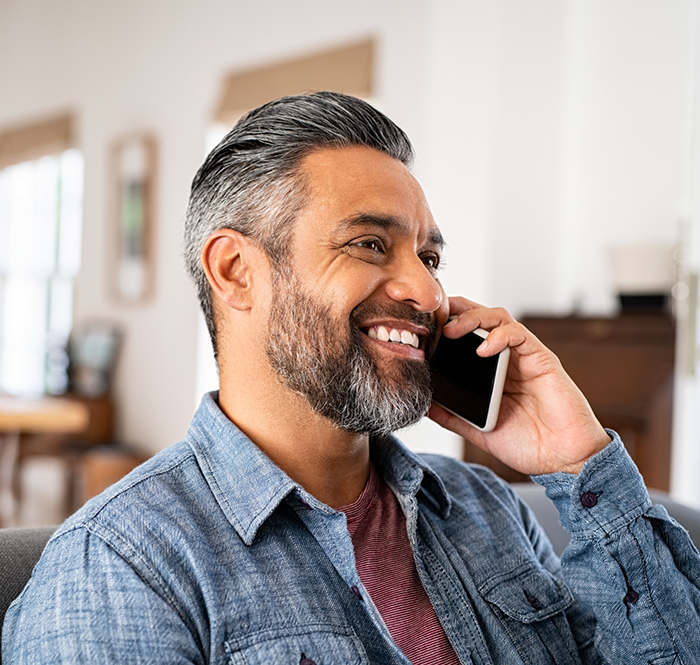 Bearded man smiling and talking on phone