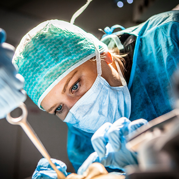 Dentist with mask performing a tooth extraction