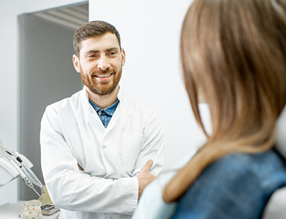 Dentist talking to patient with arms folded