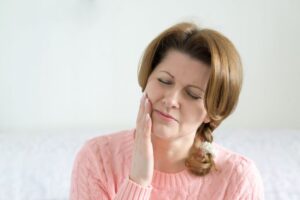 Grimacing woman dealing with facial pain